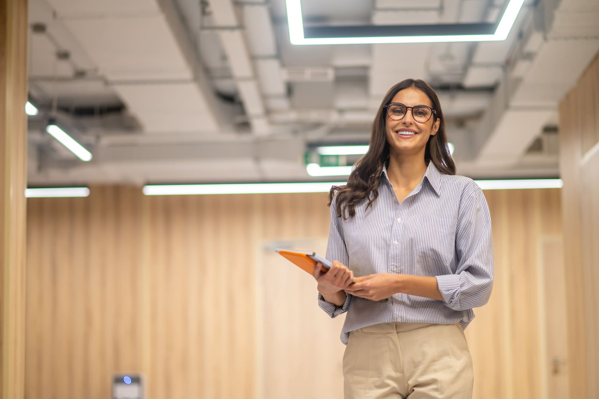 Líder sorrindo em ambiente corporativo iluminado